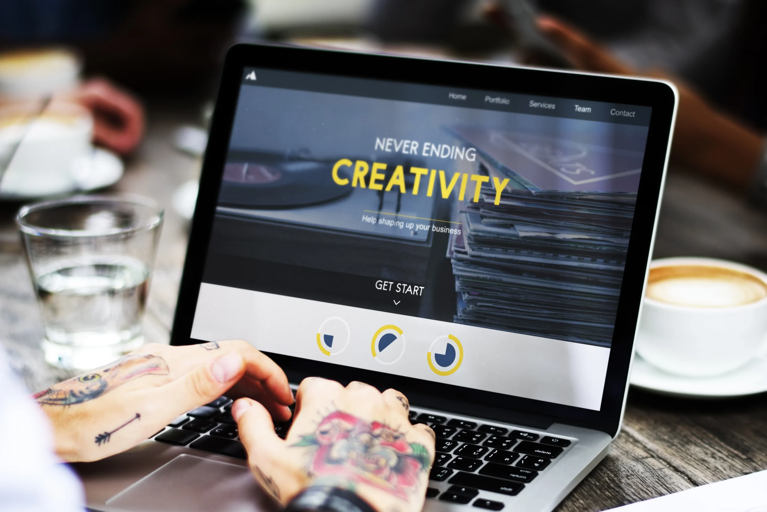 Designer typing on a laptop that shows a modern business website homepage