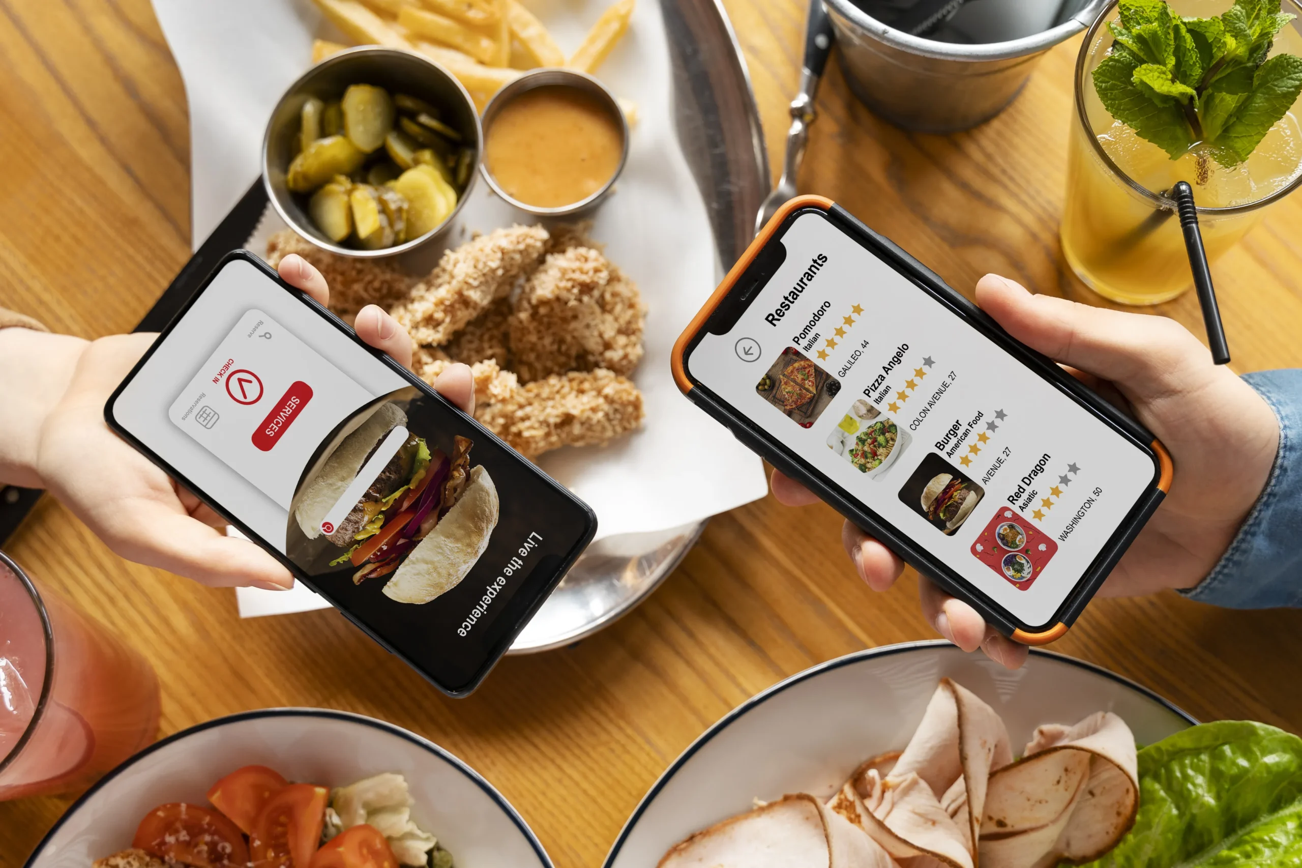 Diners browsing restaurant ordering and review apps on smartphones over a table of food